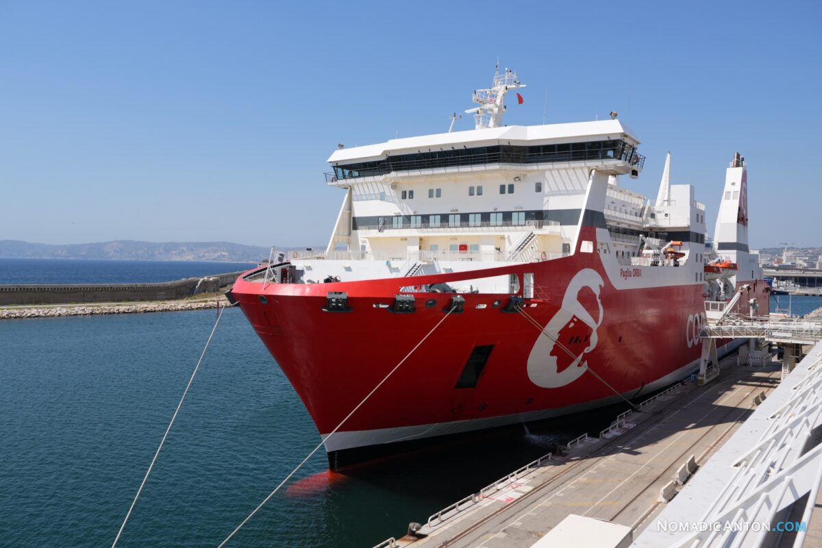Large red and white Corsica Linea ferry moored beside a quay.