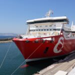 Large red and white Corsica Linea ferry moored beside a quay.