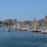 Rows of sailboats in Vieux Port with Marseille’s waterfront behind them.