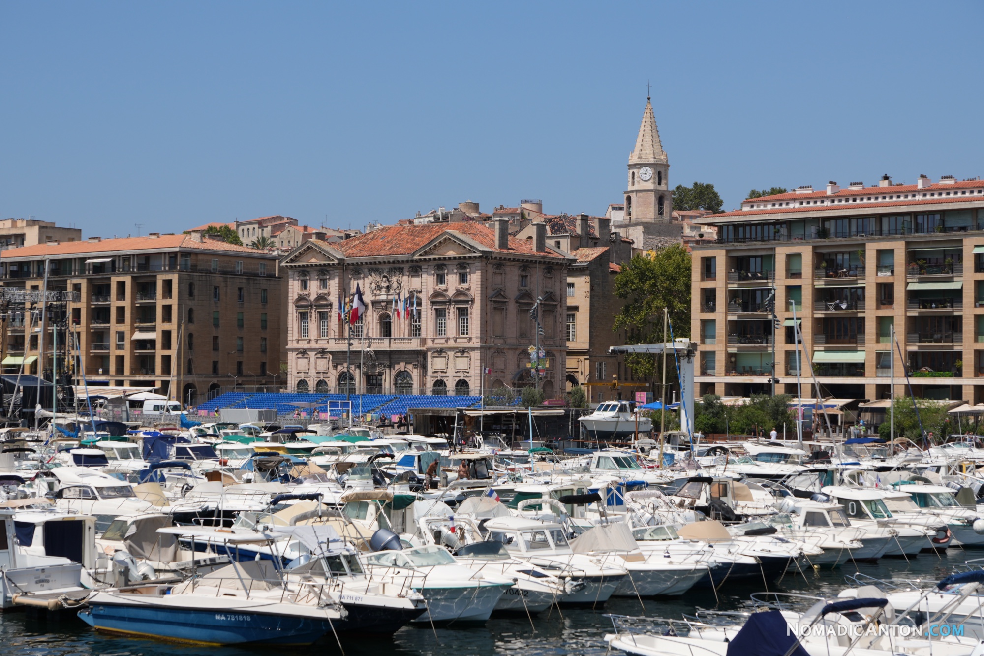 Closely moored motorboats with stone waterfront buildings behind them.