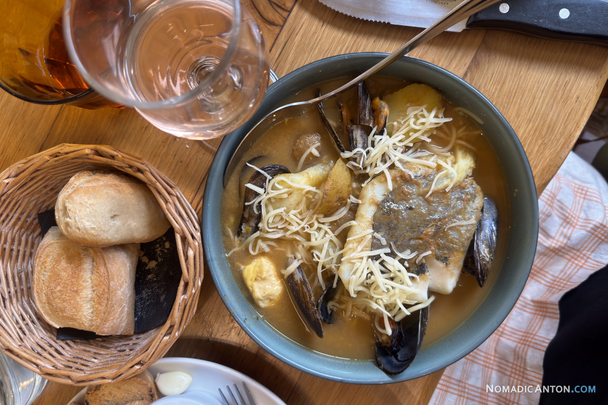 Bowl of bouillabaisse with fish and mussels in broth, served with bread