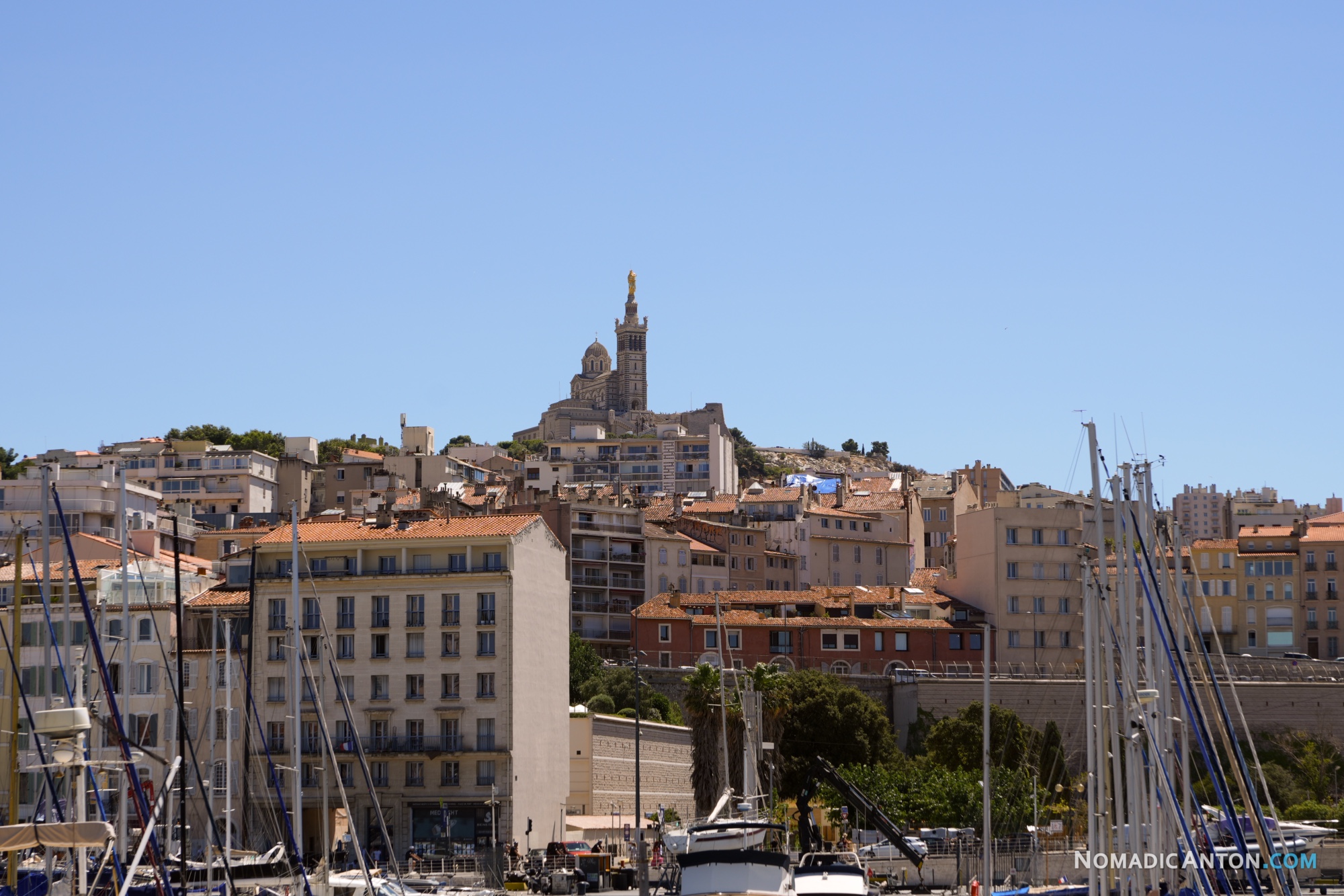 Boat masts and Marseille rooftops below Notre-Dame de la Garde.