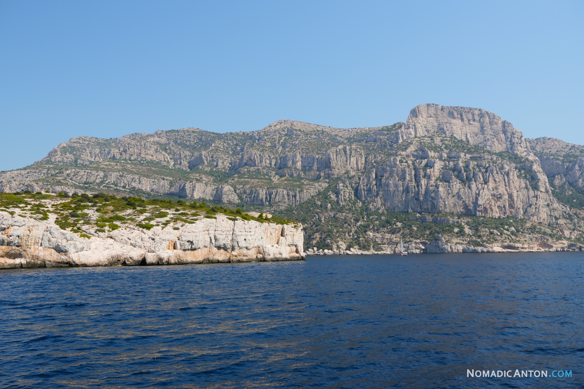 Steep limestone cliffs rising from the sea along the Calanques coast.