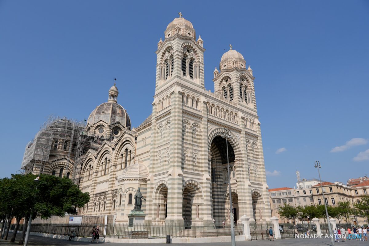 Front of Cathédrale de la Major with striped stonework and large domes.