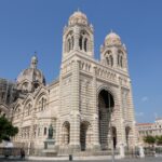 Front of Cathédrale de la Major with striped stonework and large domes.