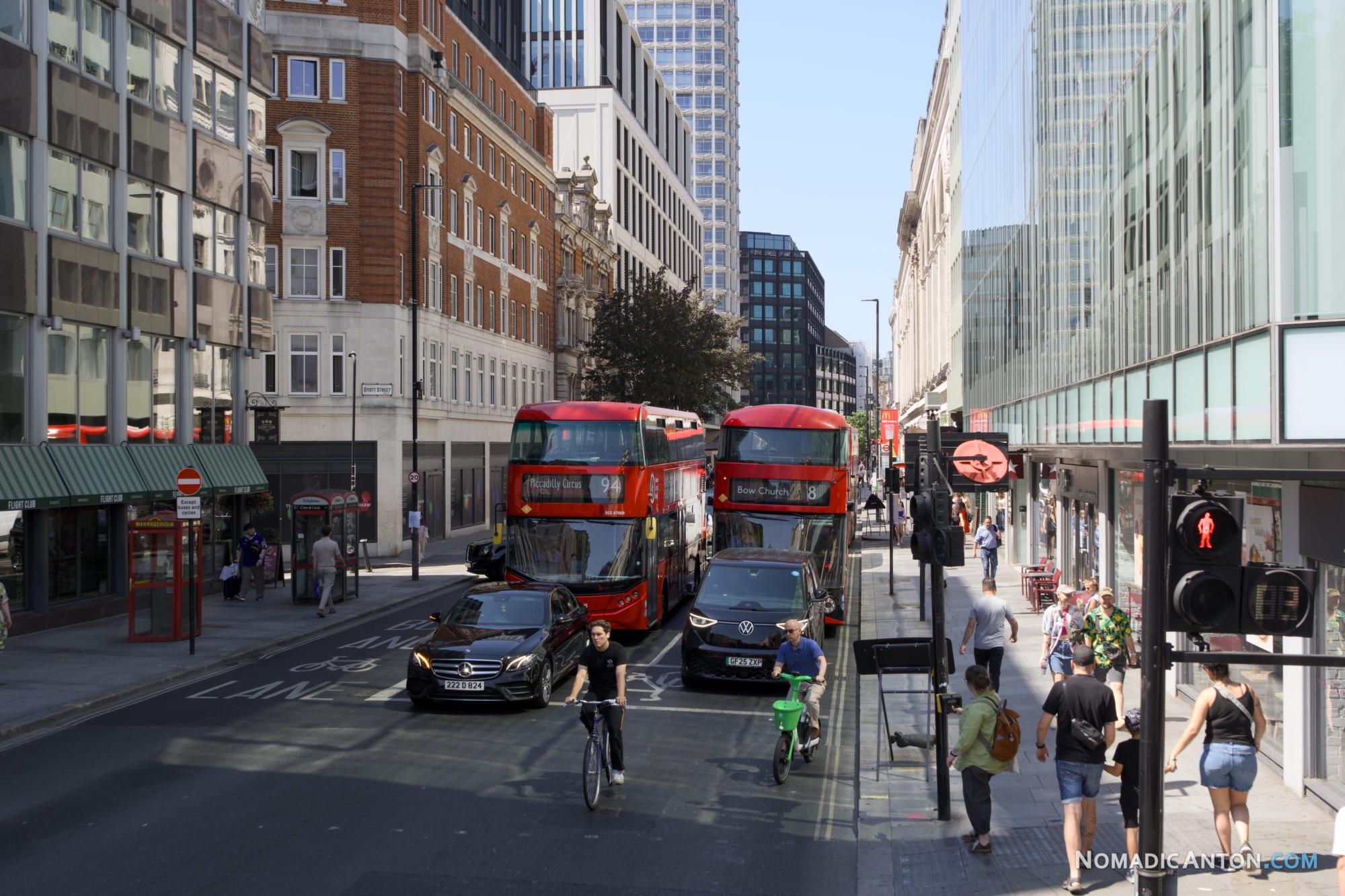 Double-decker buses, cyclists, and pedestrians on a central London street