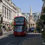 Double-decker bus on Regent Street with a domed church spire in the background